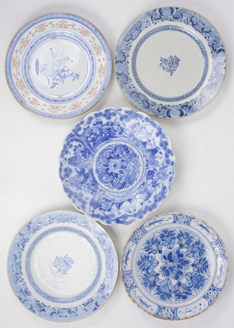 Een lot borden met blauw-witte decors, waarbij vier Chinese van porselein en een Europees van aardewerk. (Laatste met barst).