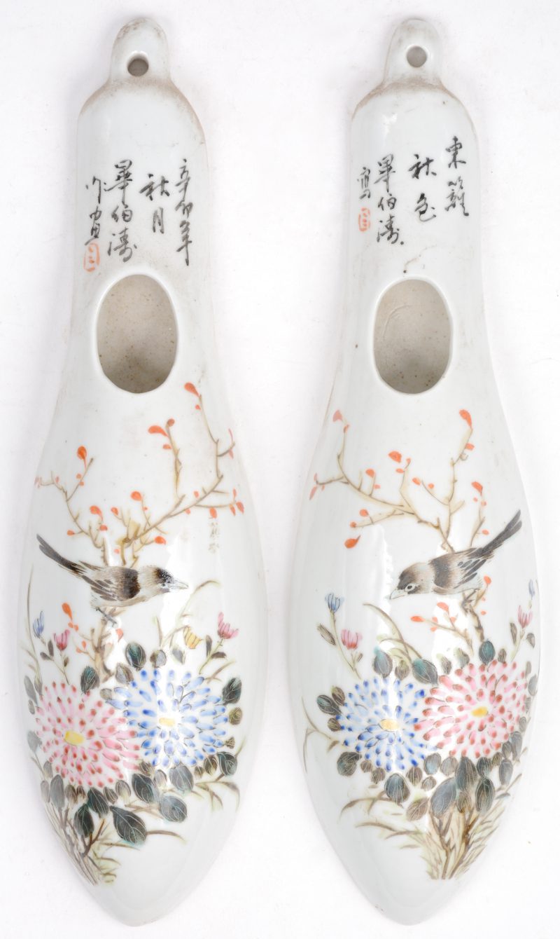 Een paar wandvaasjes van Chinees porselein met een meerkleurig decor van bloemen en vogels.