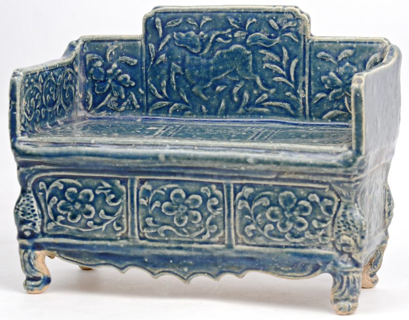 Een bankje van Chinees aardewerk met blauw glazuur.
