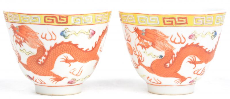 Een paar theekommetjes van Chinees porselein met een meerkleurig decor van een draak en een feniks. Onderaan gemerkt.