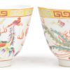 Een paar theekommetjes van Chinees porselein met een meerkleurig decor van een draak en een feniks. Onderaan gemerkt.