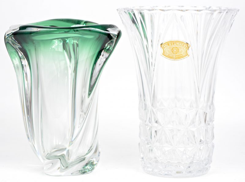Twee kristallen vazen, waarbij één geslepen kleurlozen en één groene.