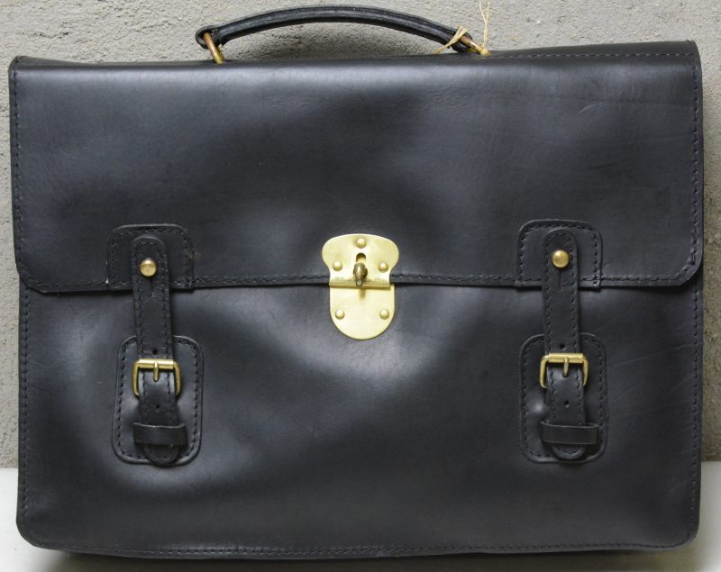 Een zwart lederen boekentas met gespen.