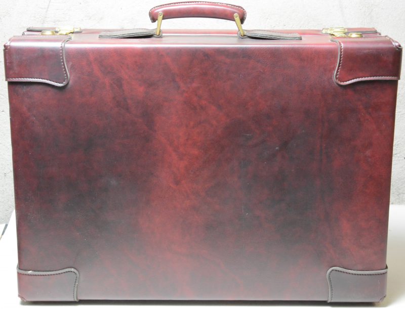 Een rood lederen reiskoffer.