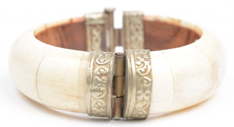 Een houten armband met ivoren plaatjes en koperen sluiting.