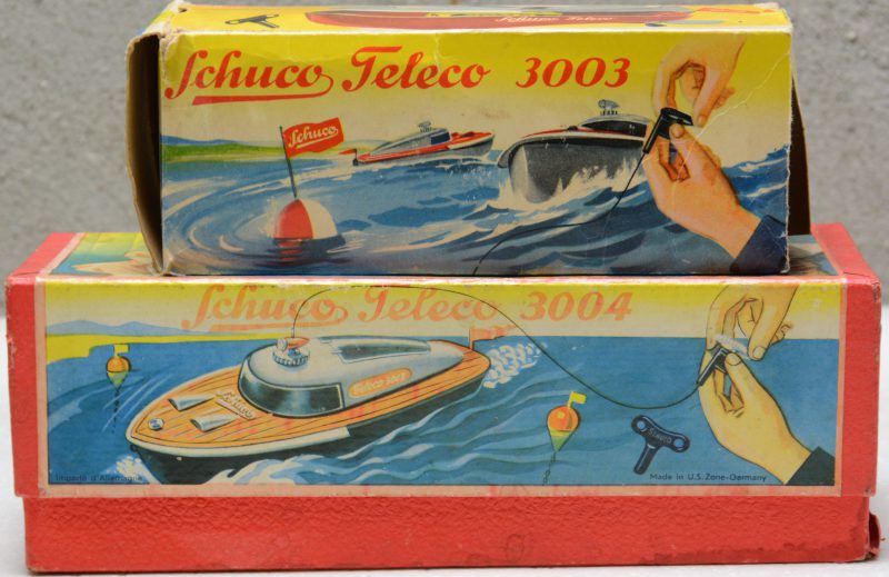 Twee op afstand bedienbare opwindbare speelgoedbootjes. In originele doosjes. Eén sleuteltje manco.