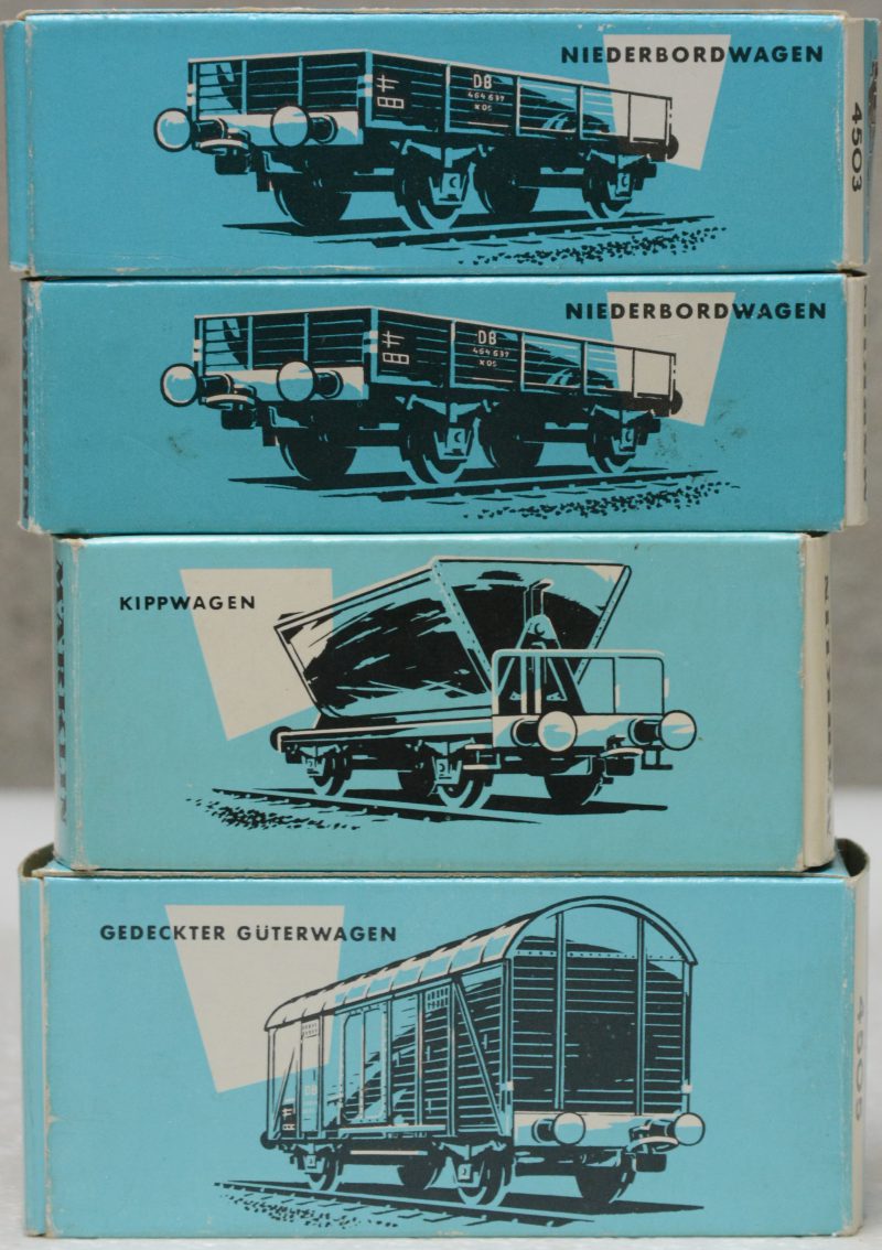 Een lot goederenwagons van de Duitse spoorwegen, bestaande uit twee platte wagons, een gesloten goederenwagon en een kipwagen op schaal HO. In originele doosjes.