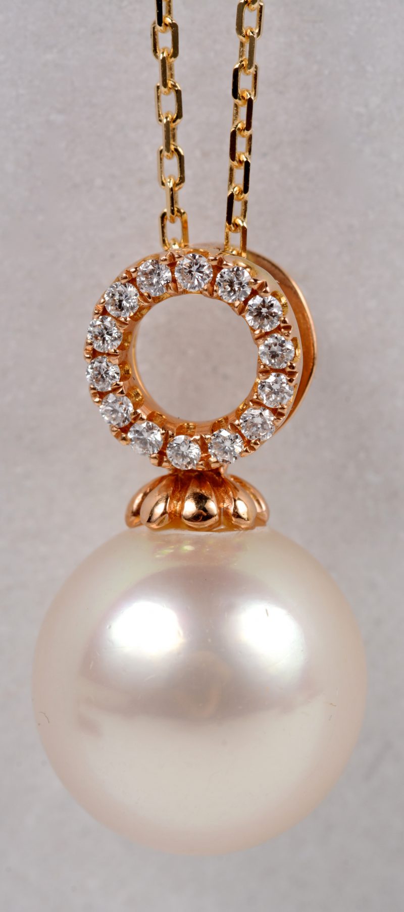 Een 18 karaats roze gouden ketting met hanger bezet met diamanten met een gezamenlijk gewicht ± 0,10 ct. GH VS. en een Australische parel. Met certificaat.