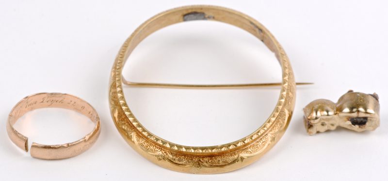 Een 18 karaats geel gouden omlijsting van een broche, een ring en losse stukjes goud.