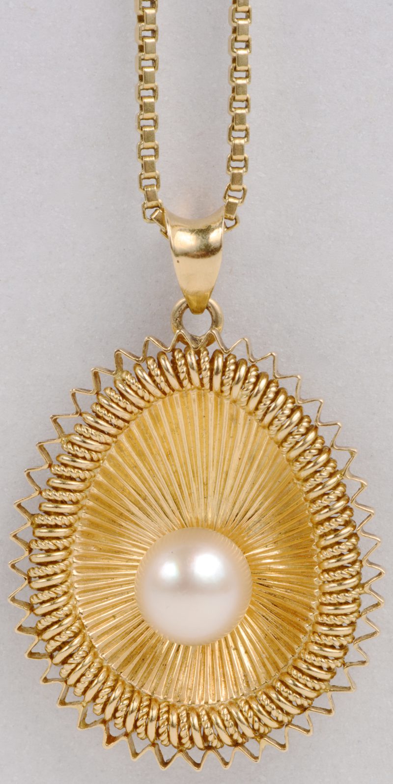 Een 18 karaats geel gouden ketting met hanger in de vorm van een schelp bezet met een parel.