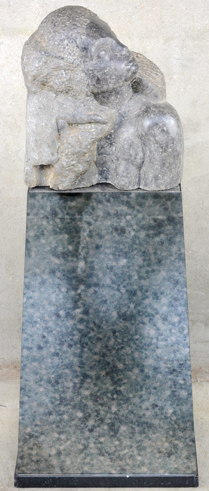 “Meisjesbuste”. Een granieten beeldhouwwerk op sokkel. Barst in de basis van de sokkel.
