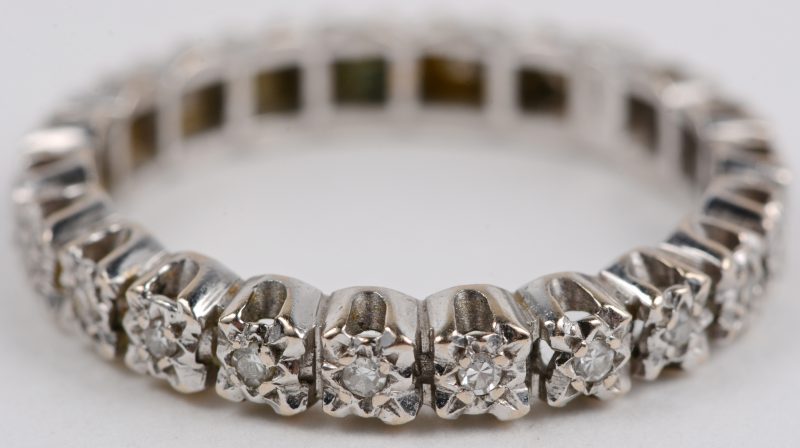 Een 18 karaats wit gouden Amerikaanse trouwring bezet met een diamanten met een gezamenlijk gewicht van ± 0,21 ct.