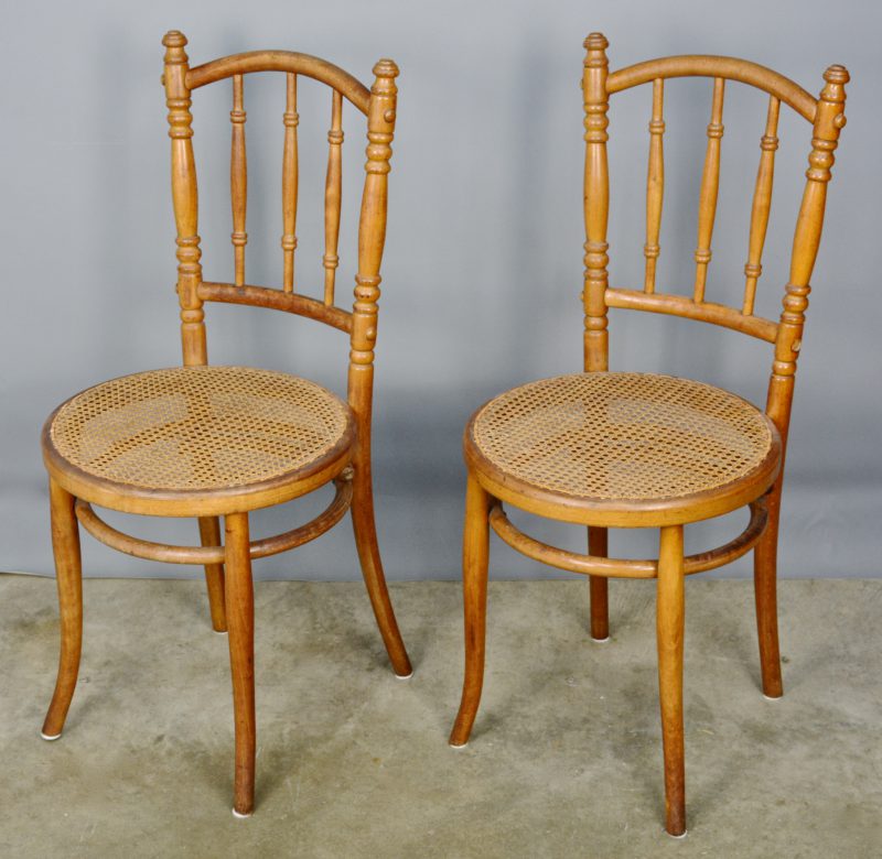 Een paar stoelen van stoomgebogen berkenhout met gecanneerde zit in de stijl van Thonet.