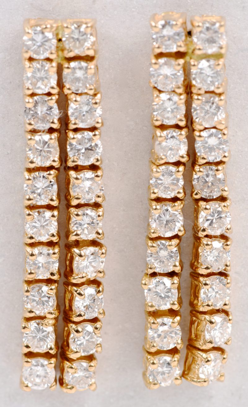 Een paar 18 karaats geel gouden oorbellen bezet met briljanten met een gezamenlijk gewicht van ± 2 ct.