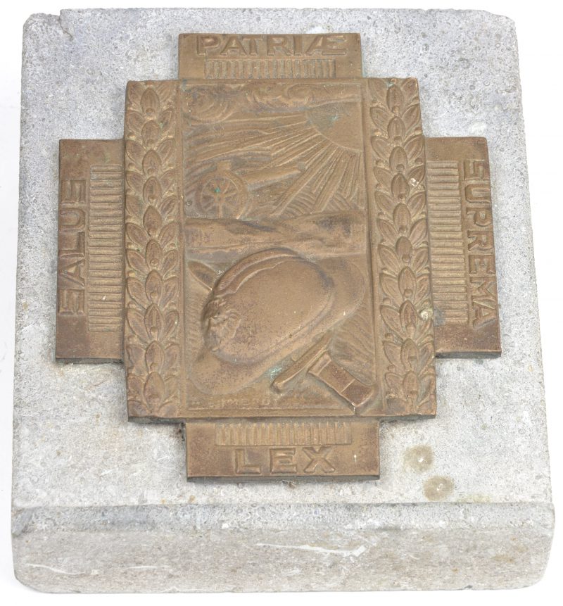 Een bronzen gedenkplaat in reliëf op stenen sokkel.