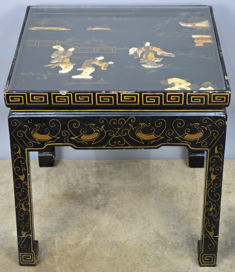 Een vierkante Chinese salontafel van zwartgelakt hout met decor van pietra dura onder glas.