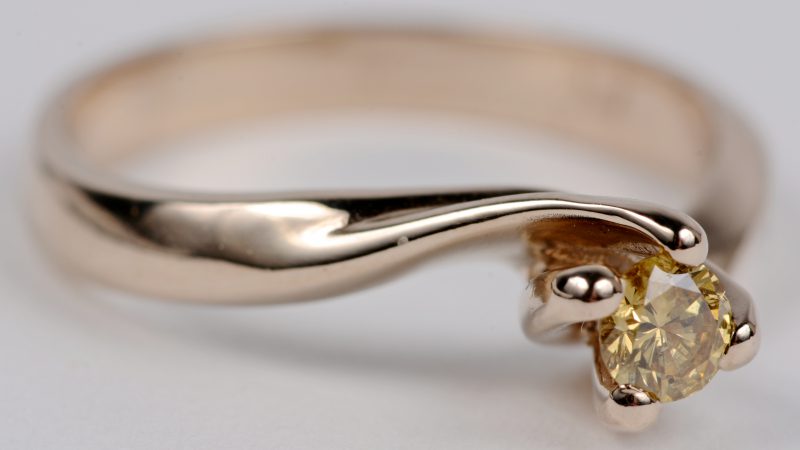 Een 18 karaats licht roze gouden ring bezet met een fancy yellow diamant van ± 0,21 ct. I1.