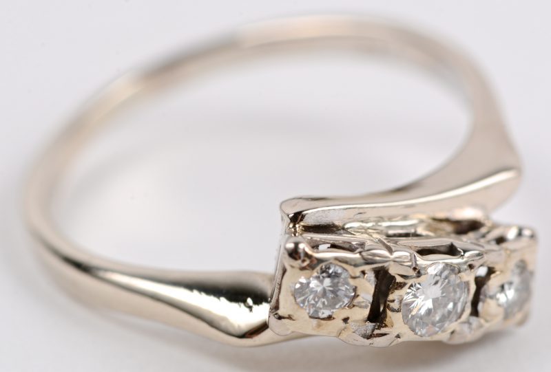 Een 18 karaats wit gouden ring bezet met diamanten met een gezamenlijk gewicht ± 0,22 ct. H. SI1.