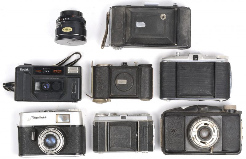 Een lot van zeven oude camera’s, waarbij twee Kodak’s, twee Voigtländers, een Zeiss Ikon, een Agfa Isolette en Aubilette. Bijgevoegd een lens van Akumar.