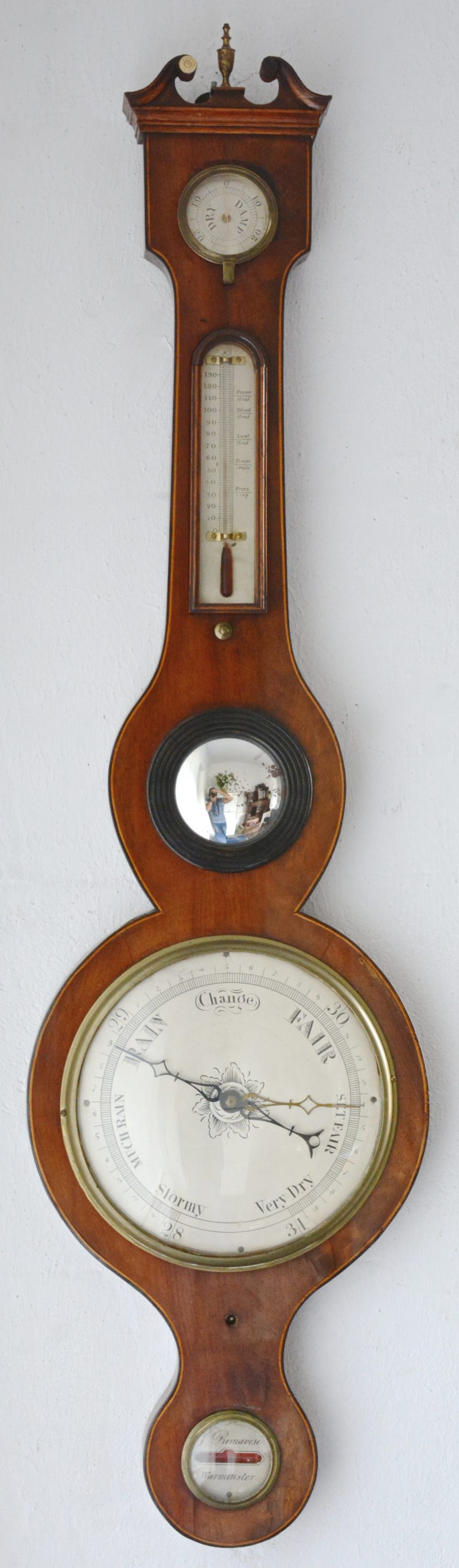 Een Engelse banjobarometer in notenhouten kast.