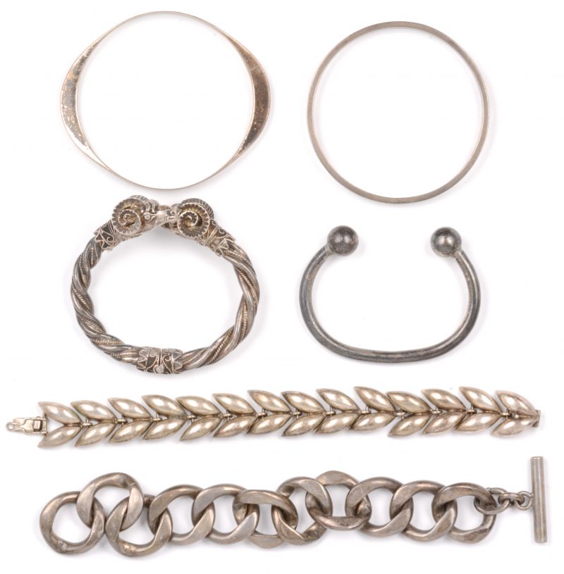 Twee slavenarmbanden en twee schakelarmbanden en één in de vorm van rammen van zilver. 835 en 925 ‰.