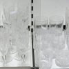 Een glasservies van geslepen kleurloos kristal, bestaande uit negen champagnefluiten, negen rodewijnglazen, negen wittewijnglazen, negen aperitiefglazen en vijf cocktailglazen.