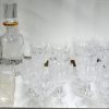 Een glasservies van geslepen kleurloos kristal, bestaande uit negen champagnefluiten, negen rodewijnglazen, negen wittewijnglazen, negen aperitiefglazen en vijf cocktailglazen.