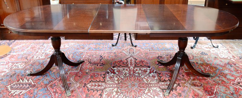 Een tafel in Regencystijl op twee voeten, telkens eindigend in drie bronzen leeuwenpoten. Met verlengblad.