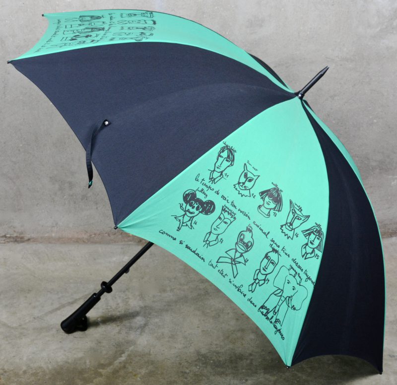 Een grote zwart en groene paraplu met karikaturen. Gesigneerd.