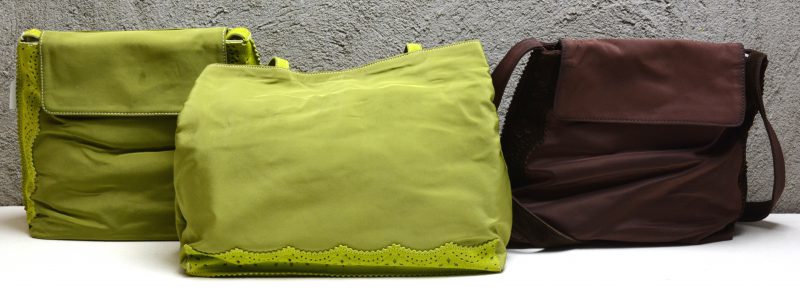 Een lot van drie handtassen van textiel en kalfsleder, waarvan twee in groen en één in bruin.