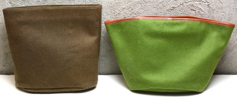Twee handtassen, waarbij één model ‘Vallon’ in groen katoen en één model ‘Coteaux’ in bruin wol. Met stofhoezen.