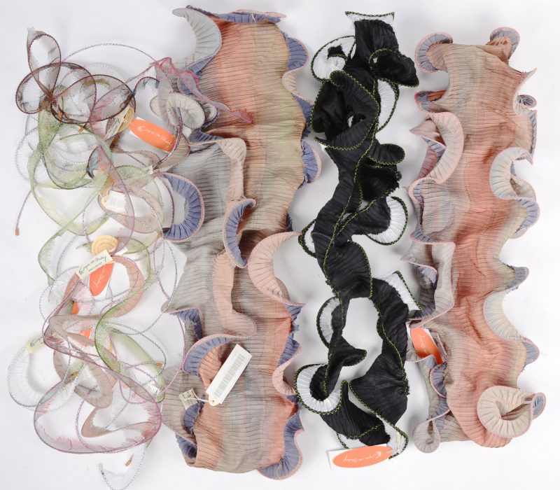 Drie verschillende kleurrijke sjaals van polyester en vier whurlgig sjaals.