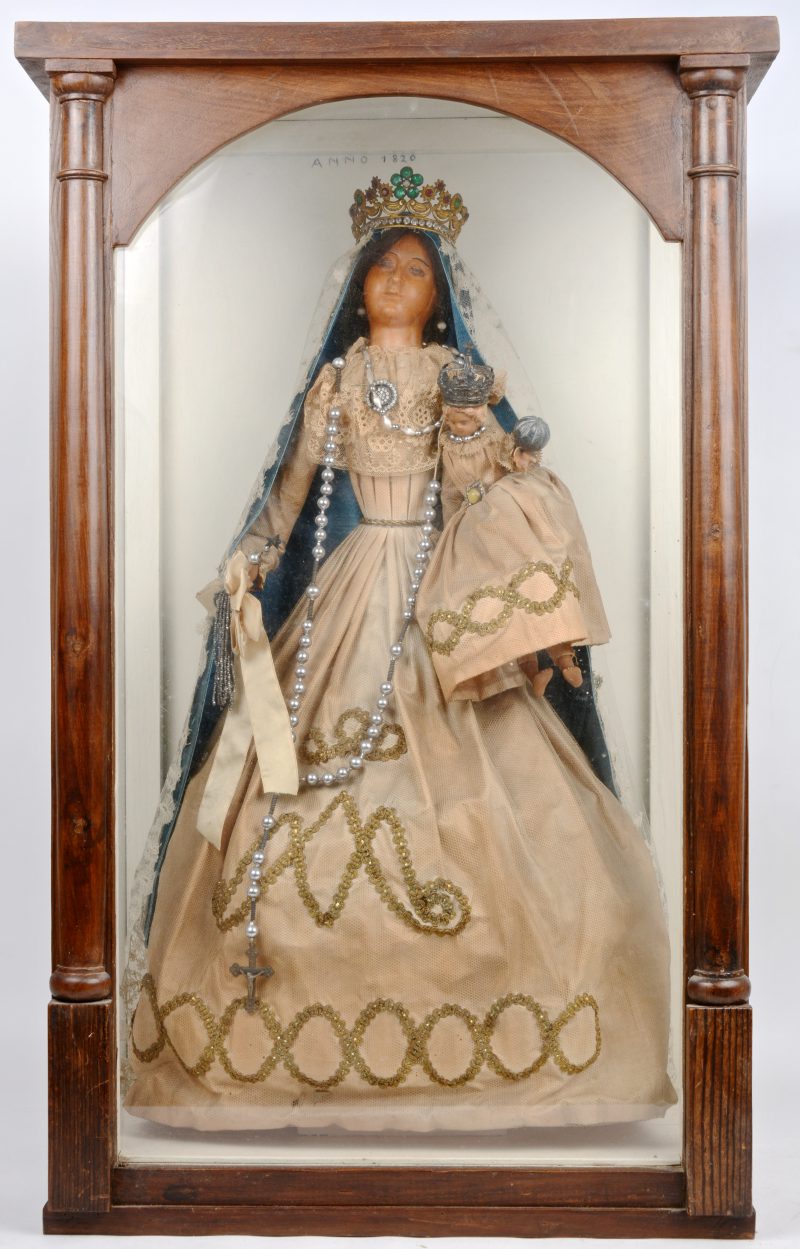 Een wassen madonna en kind met volledige originele kleding, versierd met kant. In oorspronkelijke vitrine. XIXde eeuw.