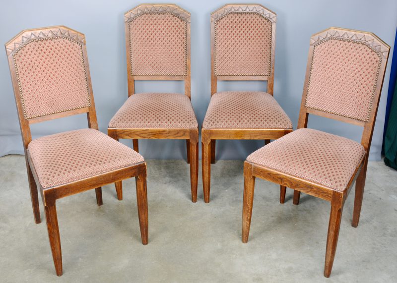 Een reeks van vier gebeeldhouwde stoelen.