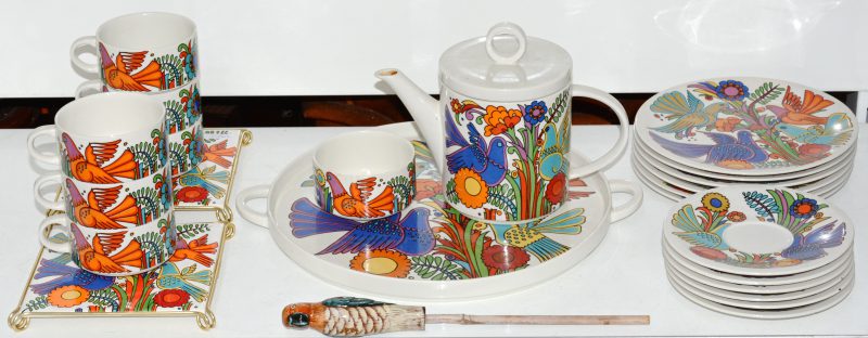 Een theeservies van porselein met een veelkleurig decor “Acapulco”. Onderaan gemerkt. Bestaande uit een theepot, een dienblad, twee onderzetters, twee kopjes zonder oor, zes kopjes en zes schoteltjes.