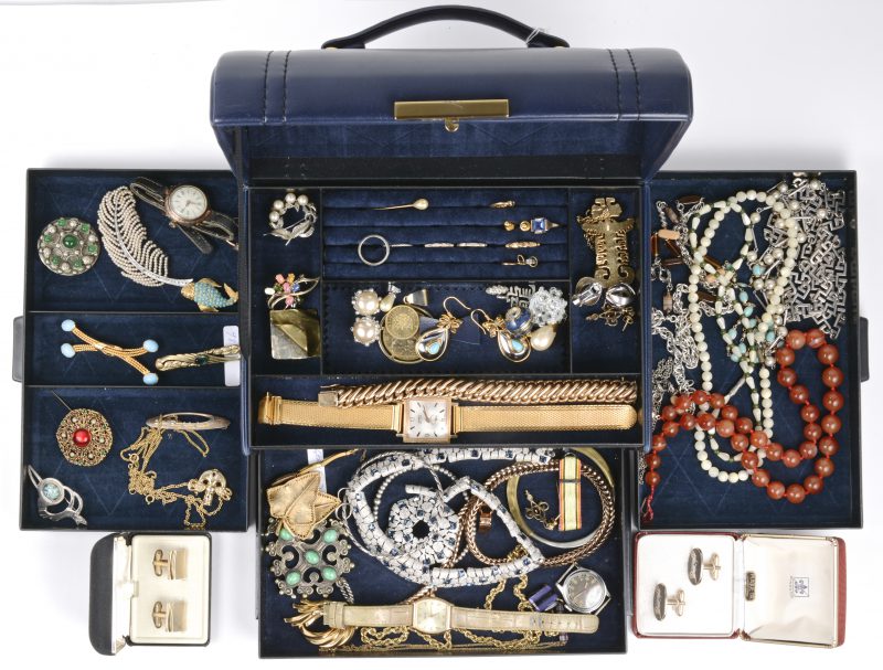 Een juwelendoos met fantasiejuwelen waaronder kettingen met hangers, oorbellen, broches, ringen, twee munten en horloges en een paar manchetknopen.
