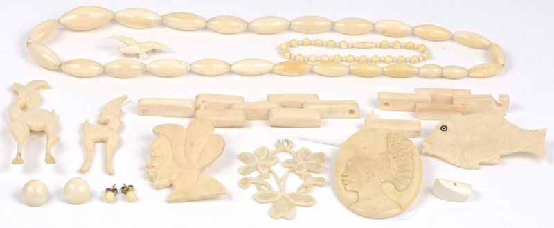 Een lot ivoren juwelen waaronder een halssnoer, een hanger, twee paar oorbellen, verschillende broches, een kleine bolletjes armband en een te herstellen armband.