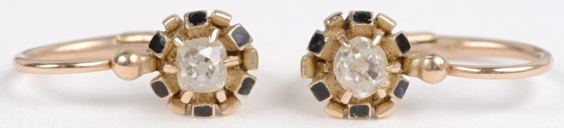 Een paar 18 karaats geel gouden oorbellen bezet met twee diamanten oude slijp met een gezamenlijk gewicht van ± 0,30 ct.