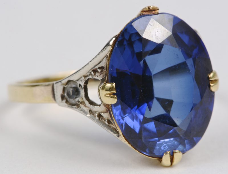 Een 18 karaats geel gouden ring bezet met een donkerblauwe kleursteen van ± 5 ct.