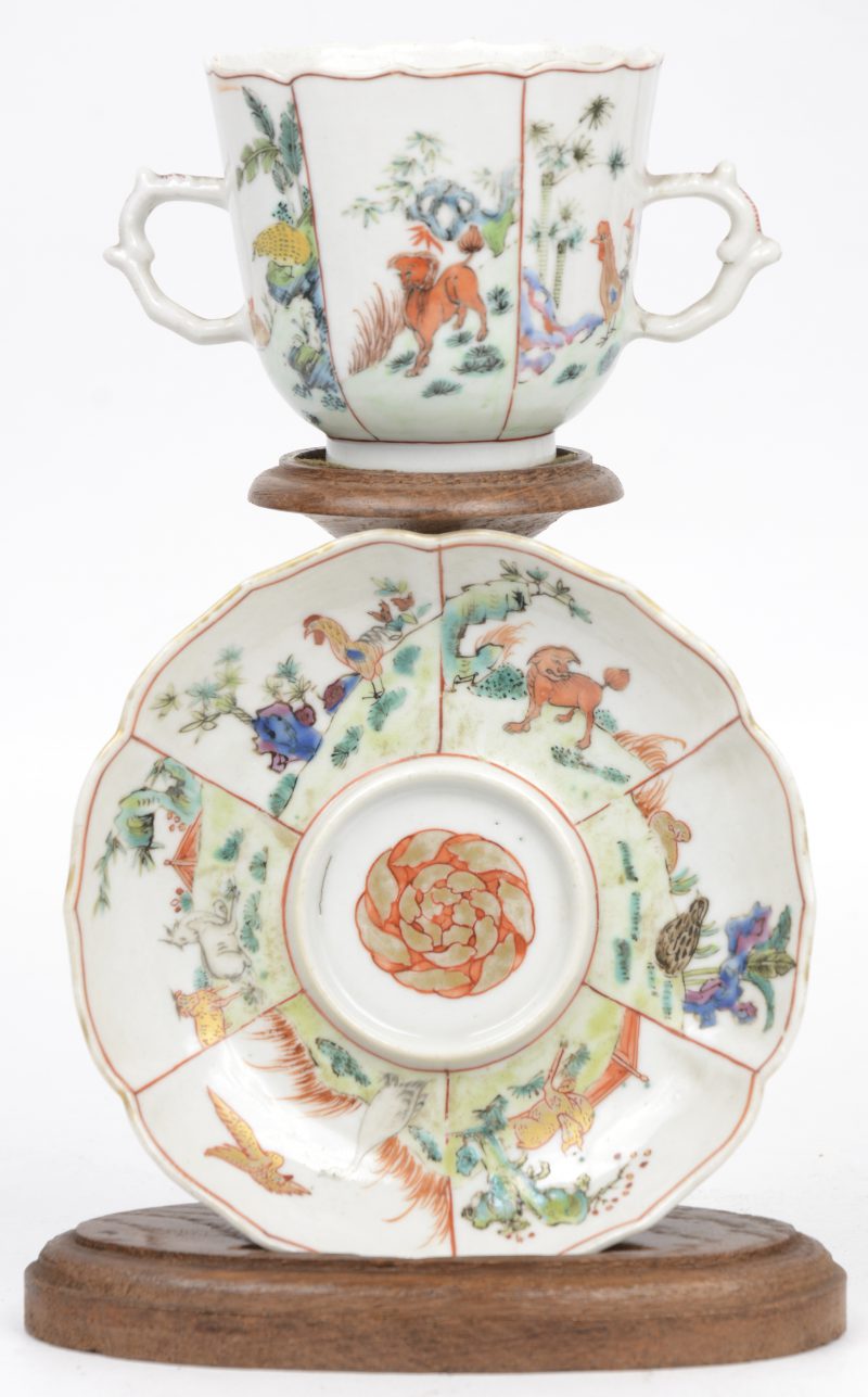 Een porseleinen kopje en schoteltje met twee oren en met een decor van dieren in een landschap. Chinees werk, XVIIIde eeuw.