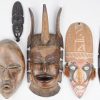 Twaalf stuks Afrikaanse kunst: beeldjes, maskers, een staf met hoofden van gebeeldhouwd hout, een stenen beeldje en een bronzen duiveltje.
