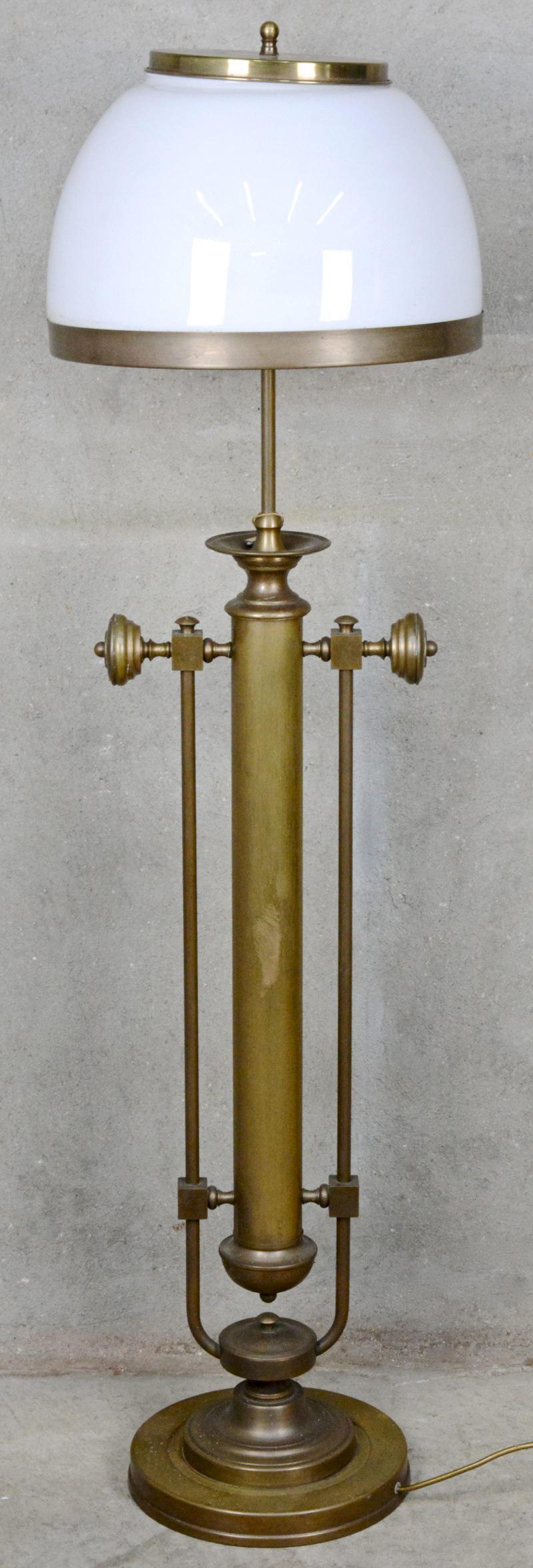 Een messingen staande lamp met grote bolle kap van melkglas. Medio XXste eeuw.