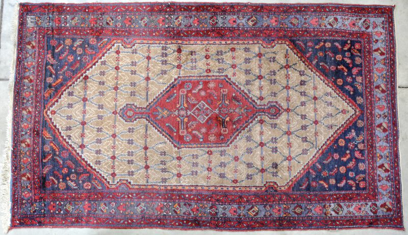 Een antiek handgeknoopt Perzisch wollen karpet.