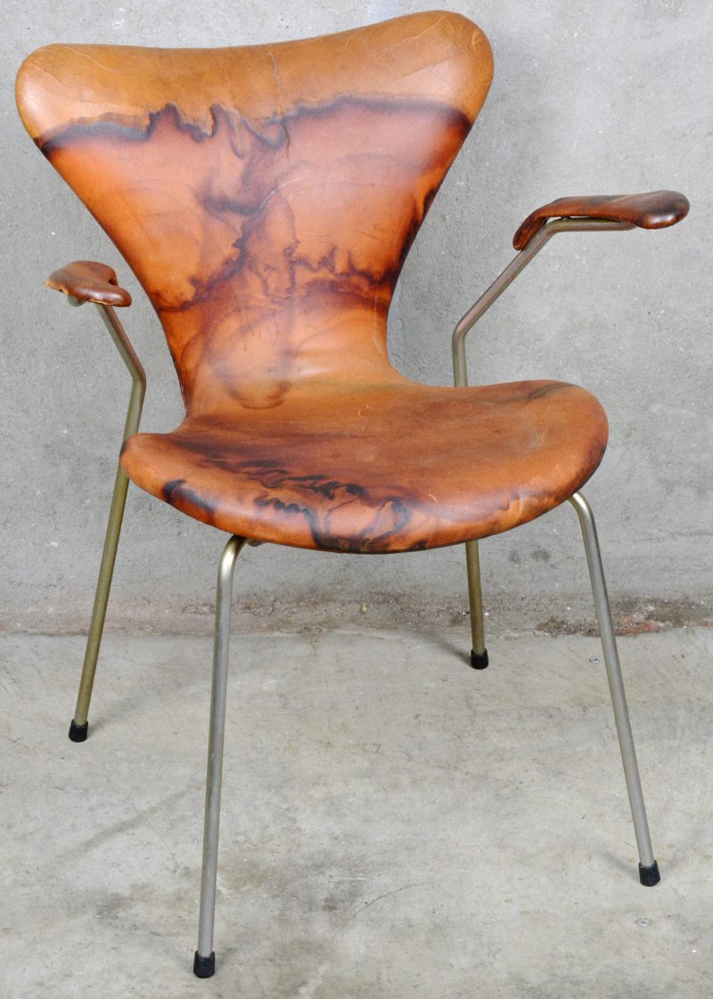 Een met leder beklede Seven chair met armleuningen naar ontwerp van Arne Jacobsen uit de jaren ‘50. Onderaan gemerkt. Lichte slijtage.