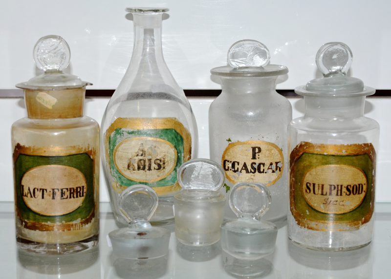 Een lot van vier antieke glazen apothekerspotjes. Met drie extra stoppen.