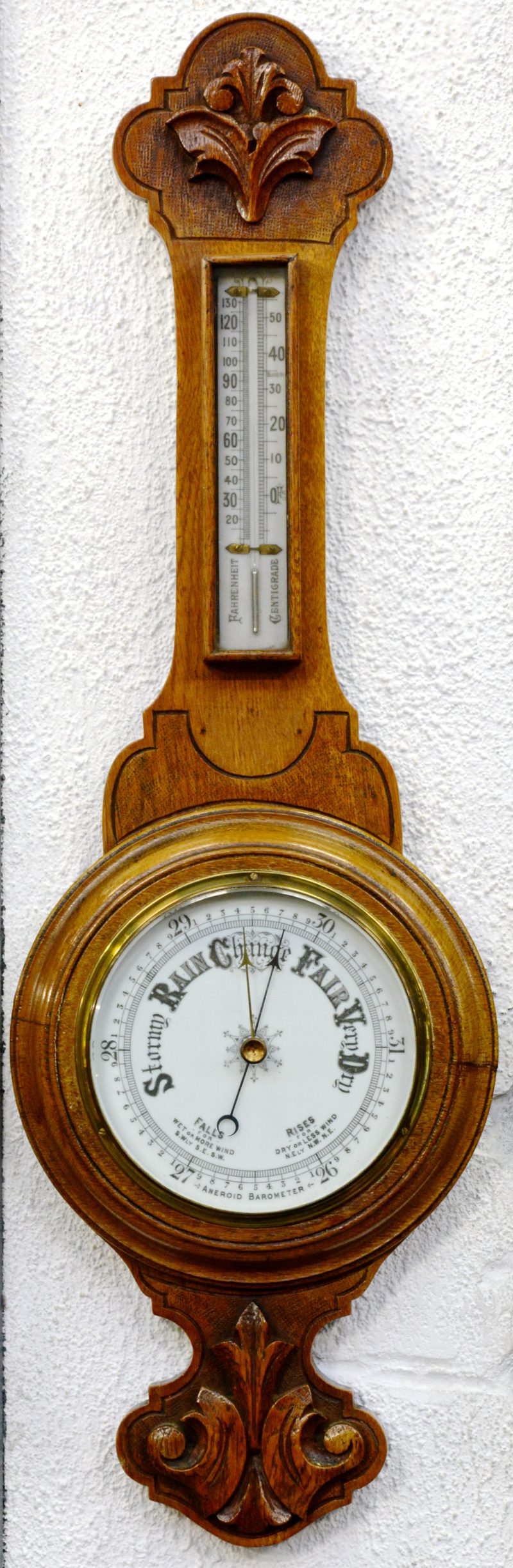 Een Engelse barometer in eikenhouten kast.