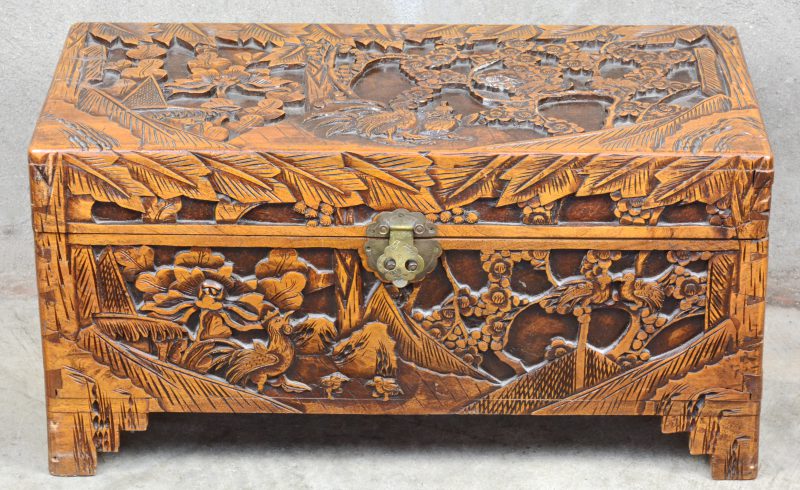 Een Chinese houten koffer, versierd met gesculpteerde decors van vogels in een landschap.