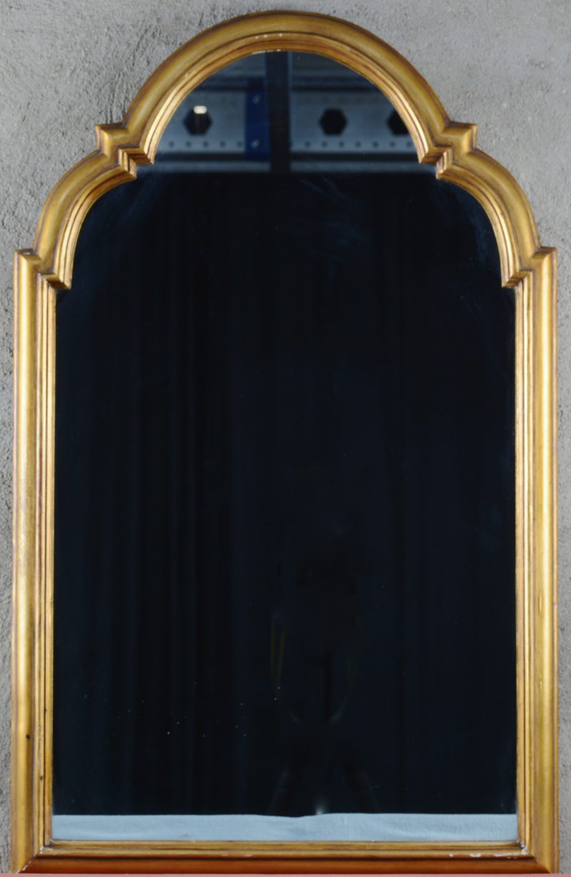 Een spiegel in verguld houten lijst.