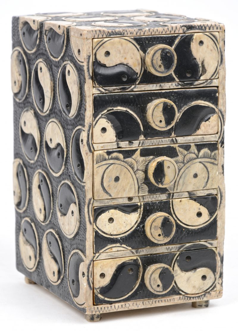 Een antiek stenen juwelenkastje met vijf schuifjes, versierd met Yin en Yangtekens.