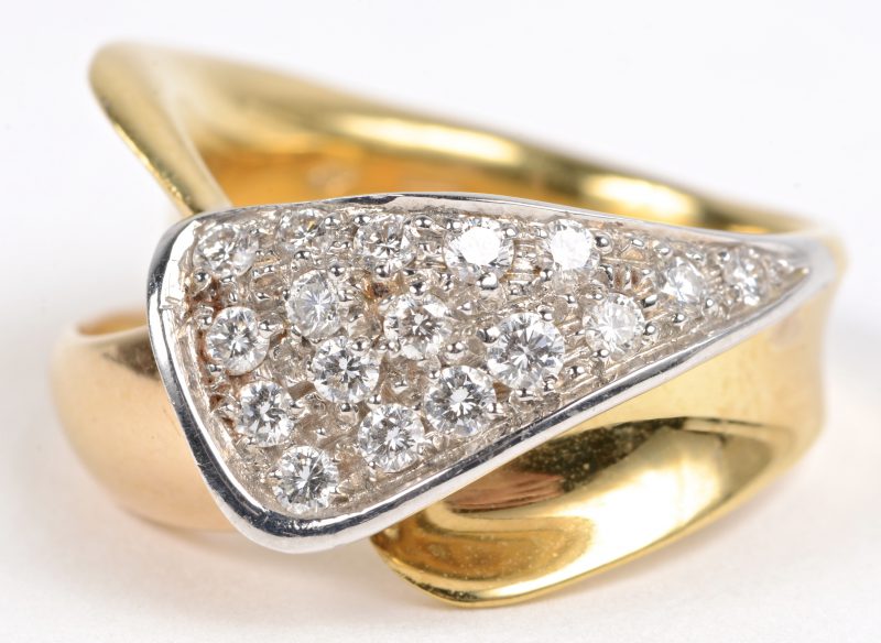 Een 18 karaats wit en geel gouden ring bezet met briljanten met een gezamenlijk gewicht van ± 0,50 ct.